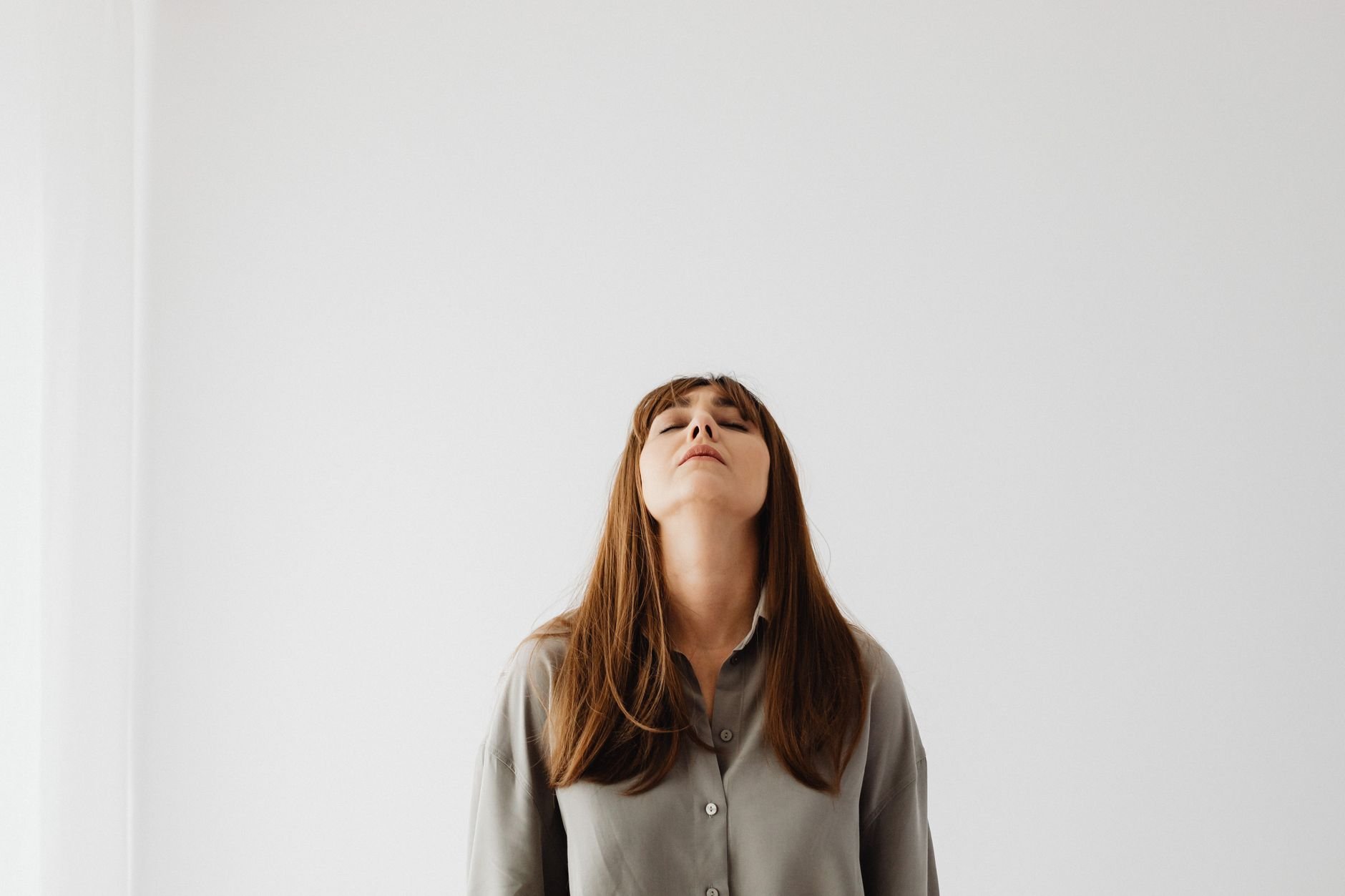 Calm woman with eyes closed, standing still, conveying tranquility.